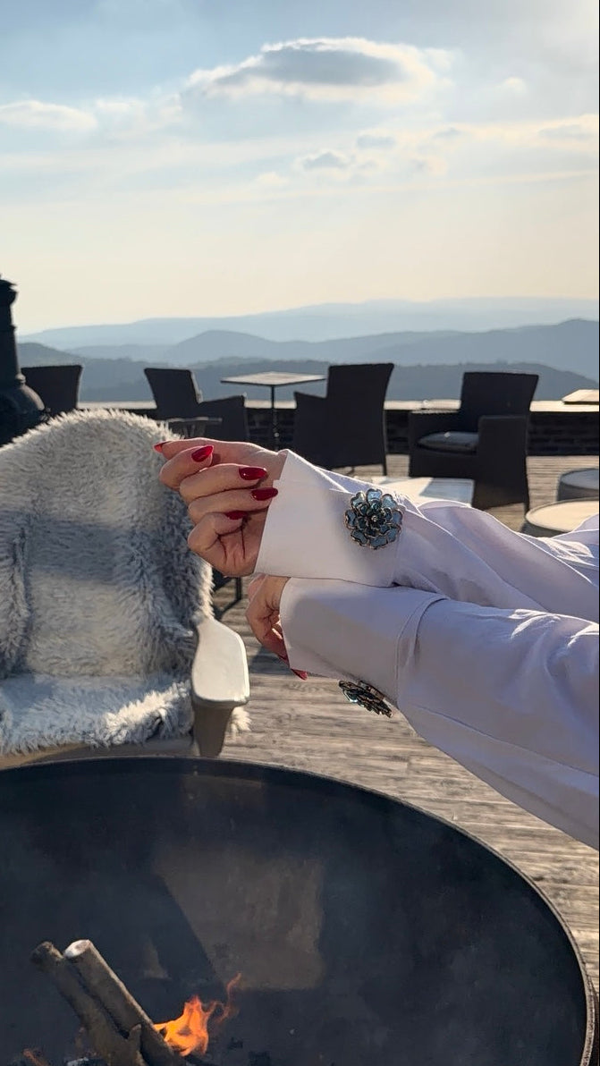 KALMAÉ accessory styled on a white shirt outdoors